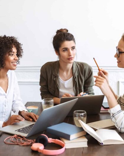 group of cheerful young women studying together