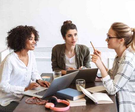 group of cheerful young women studying together