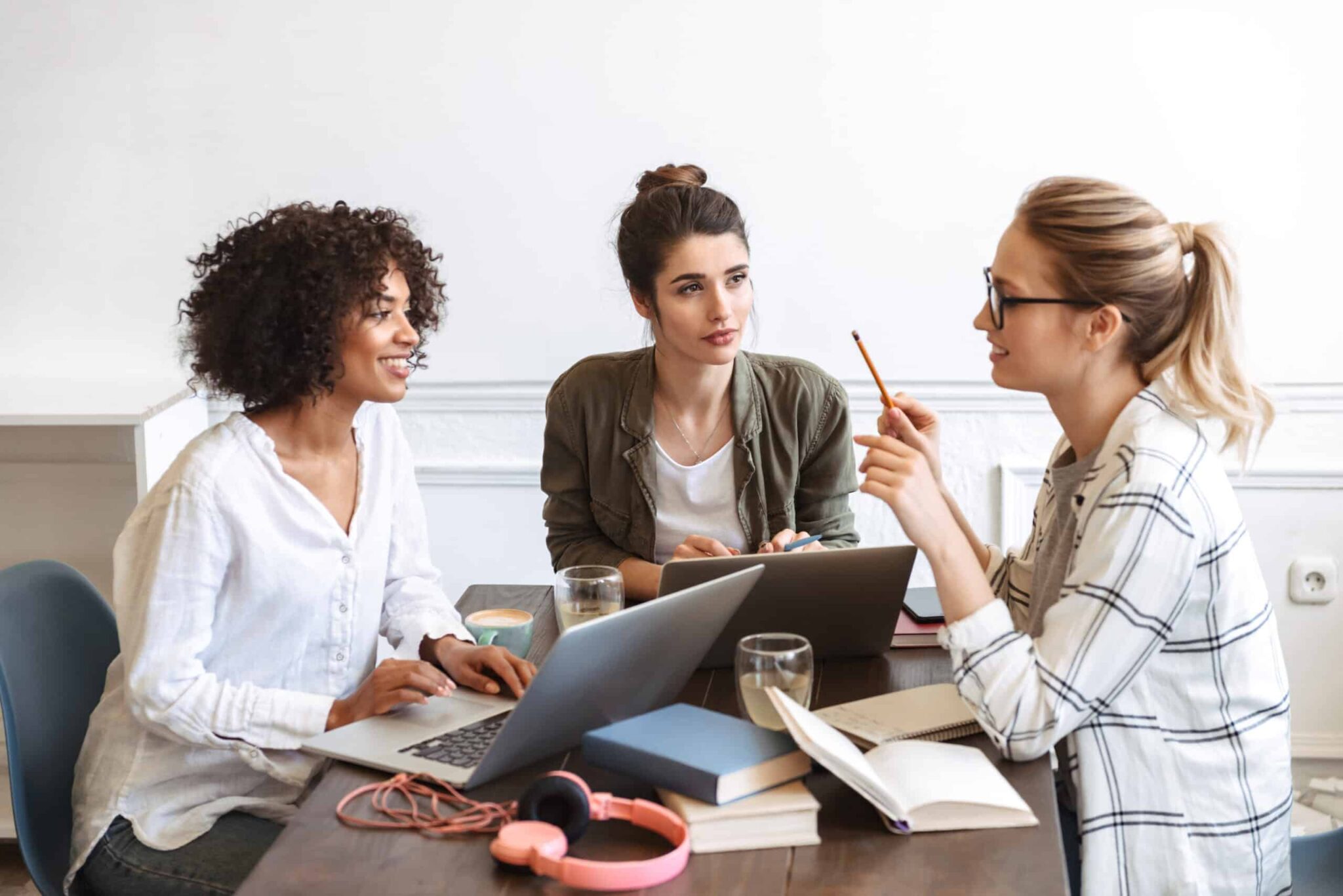 group of cheerful young women studying together