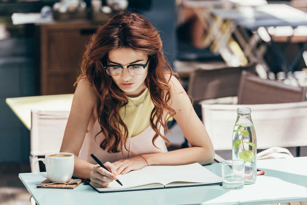 woman writes in notebook