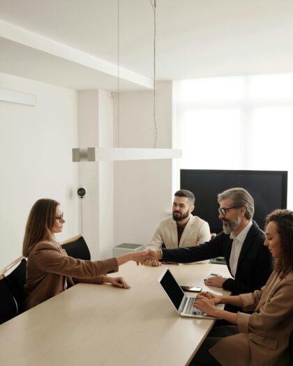 people shaking hands across conference table
