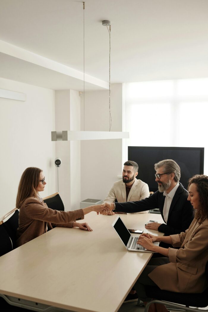 people shaking hands across conference table