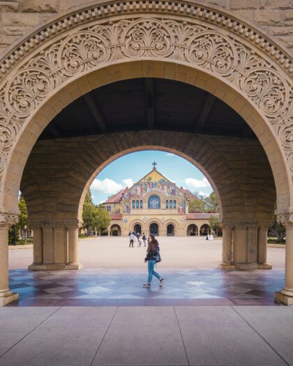 Female student standing in Stanford Law School courtyard, looking back at the camera.
