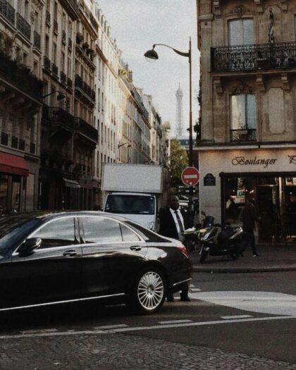 Business man in paris street next to black town car