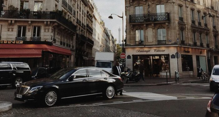 Business man in paris street next to black town car