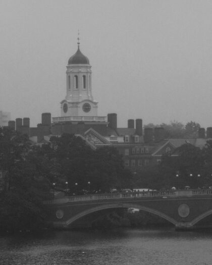 Black and white photo of Harvard University tower overlooking the river