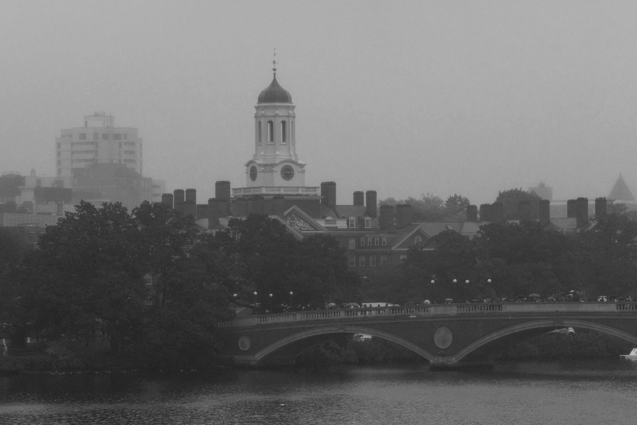 Black and white photo of Harvard University tower overlooking the river