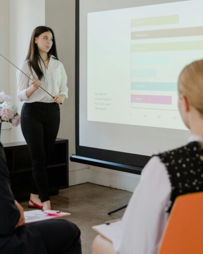 Woman in business attire giving presentation to two other people in business attire