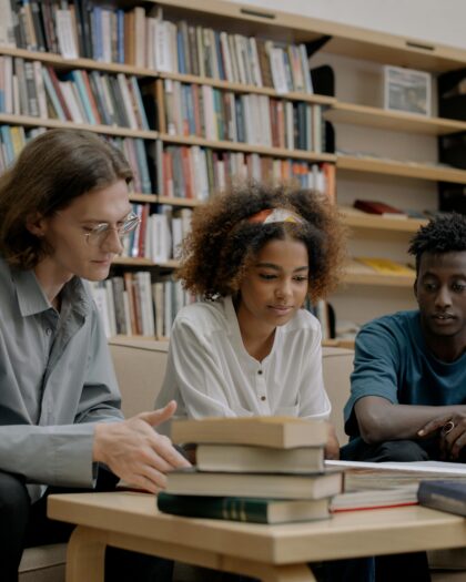 Three college aged students studying in library