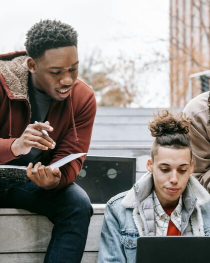 Three college students studying on campus stairs