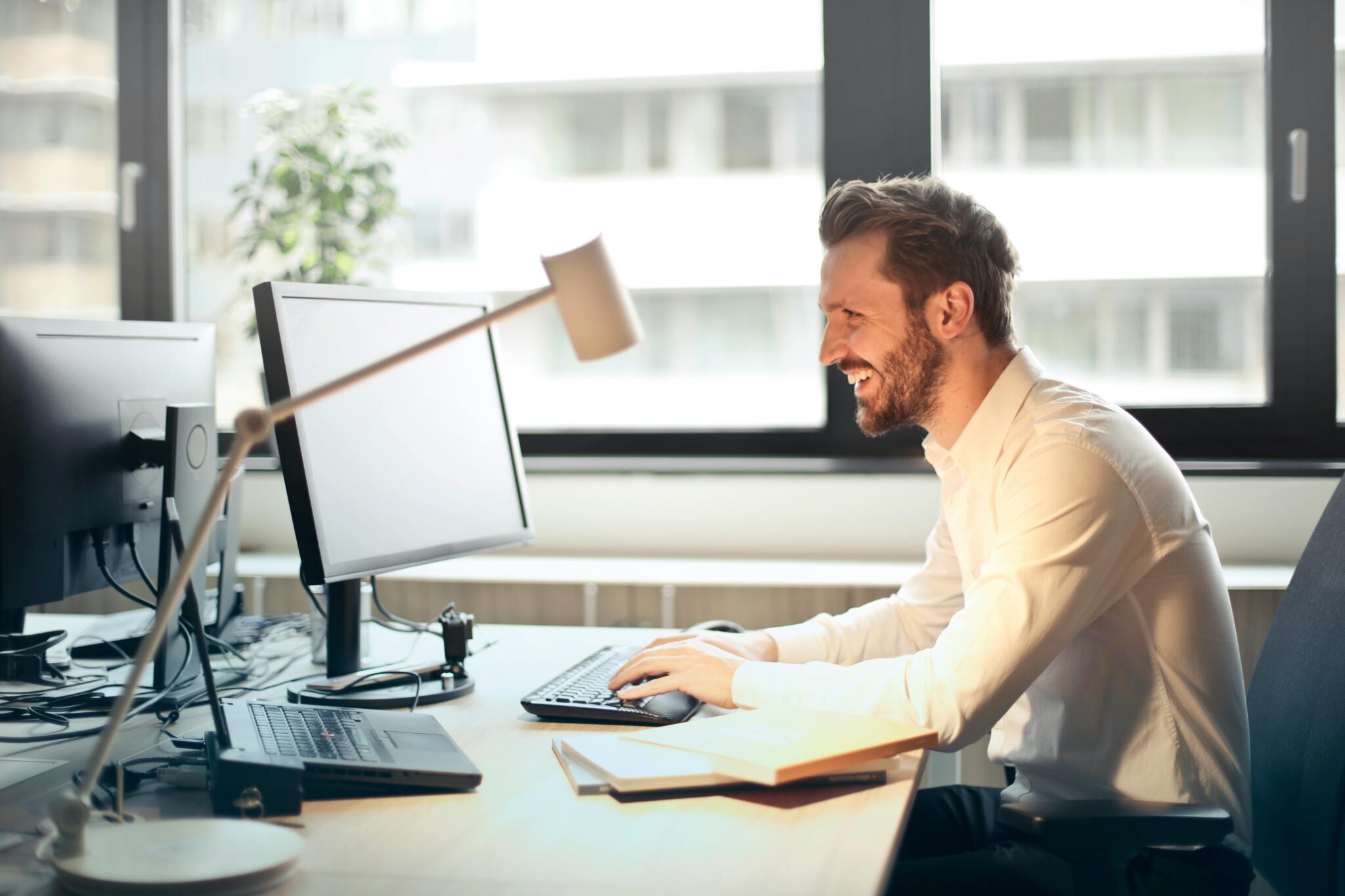 Man in business attire sitting at desk looking at computer screen
