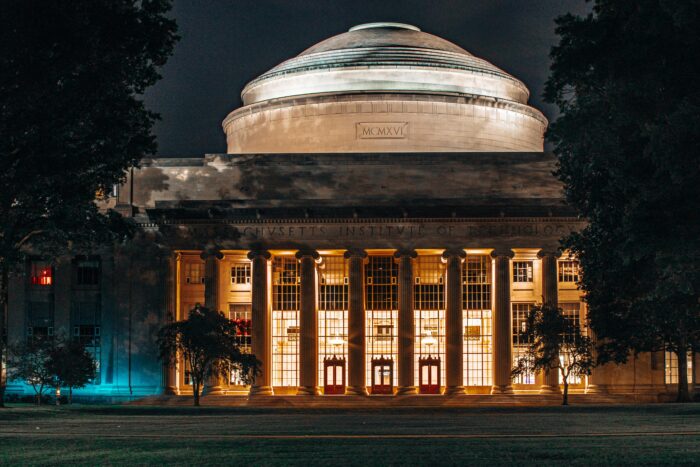 Grand greek-style building with pillars and dome on top with "Massachusetts Institute of Technology" inscribed across the stone molding