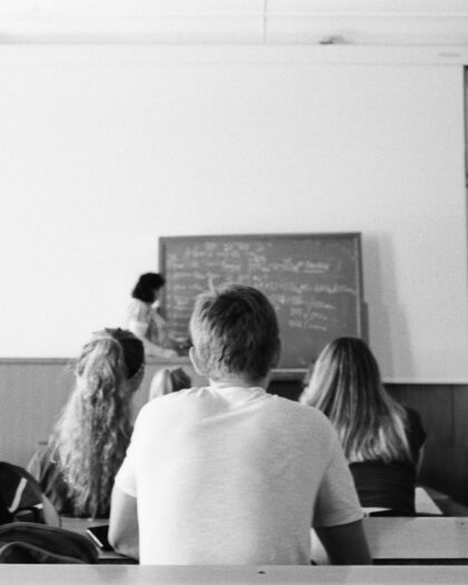 A Grayscale Photo of People Sitting in a Room