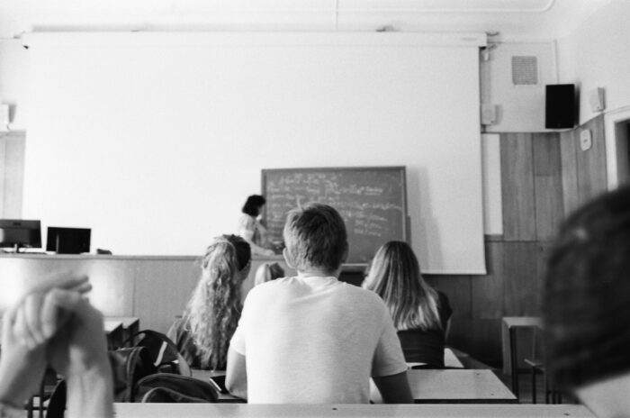 A Grayscale Photo of People Sitting in a Room