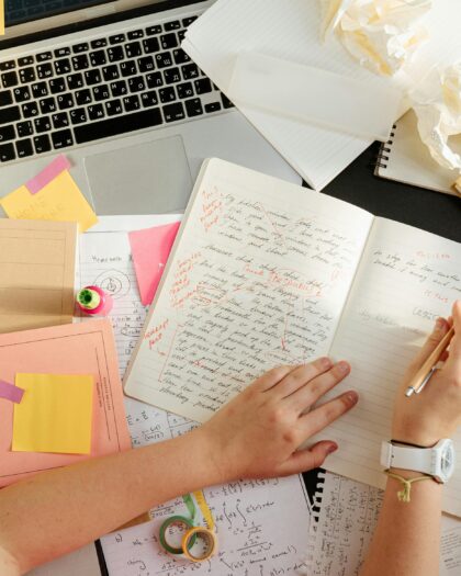 Person Writing on a Notebook