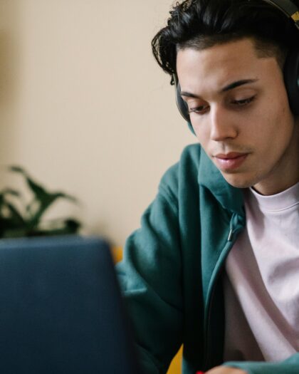 Concentrated man in headphones working on laptop at home