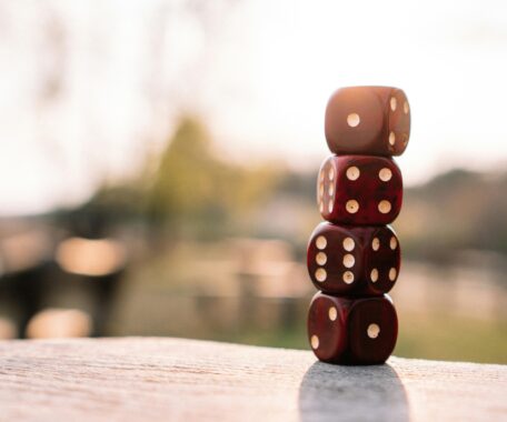 Four dice stacked atop one another on an outdoor table