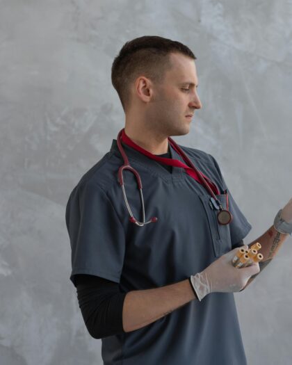 A Man in Scrub Suit Holding Specimen Test Tube