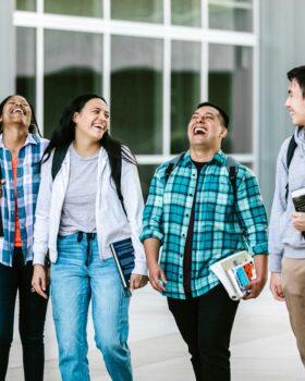 Four students walking and laughing together