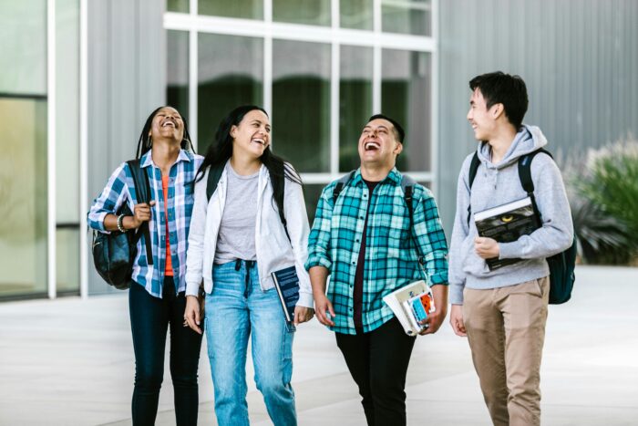 Four students walking and laughing together