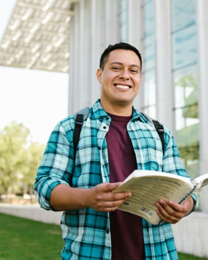 Man in Blue Red and White Plaid Dress Shirt Holding a Book