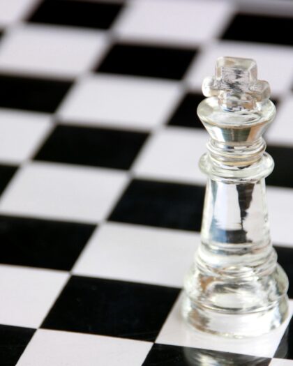 Clear king chess piece on black and white chess board