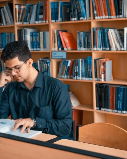 Man Reading a Book Inside the Library