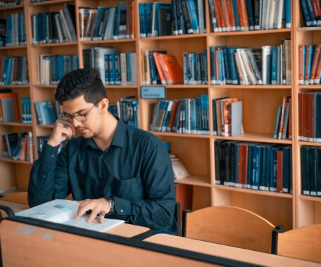 Man Reading a Book Inside the Library
