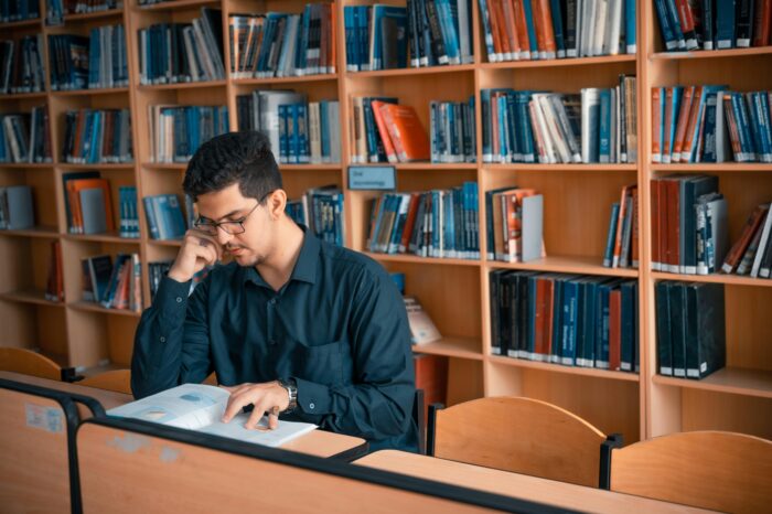 Man Reading a Book Inside the Library