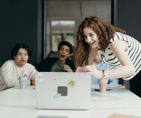 People Laughing Looking at a Laptop