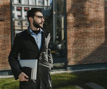 Man Wearing Black Jacket Holding Laptop Computer