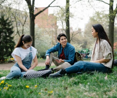 Photo of a Group of Friends Sitting on the Grass