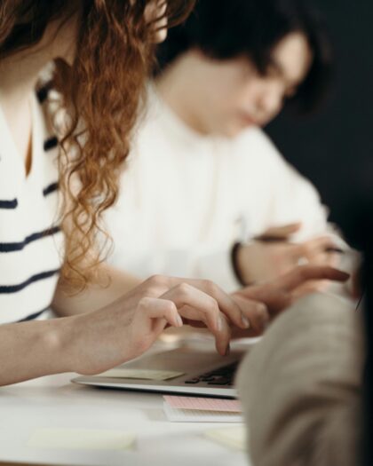 Woman in White and Black Stripe Top Typing