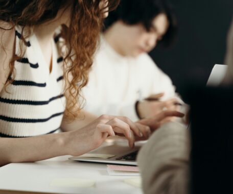 Woman in White and Black Stripe Top Typing