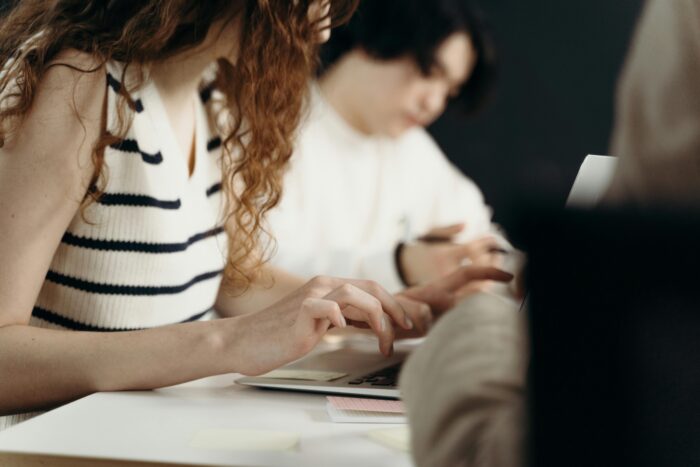 Woman in White and Black Stripe Top Typing