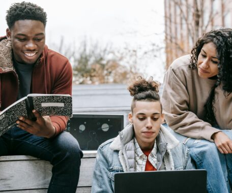 Multiethnic group of young people studying with notebook and laptop