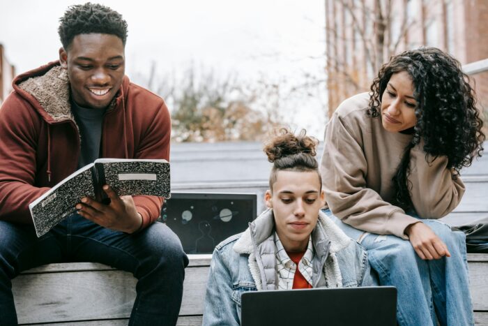 Multiethnic group of young people studying with notebook and laptop