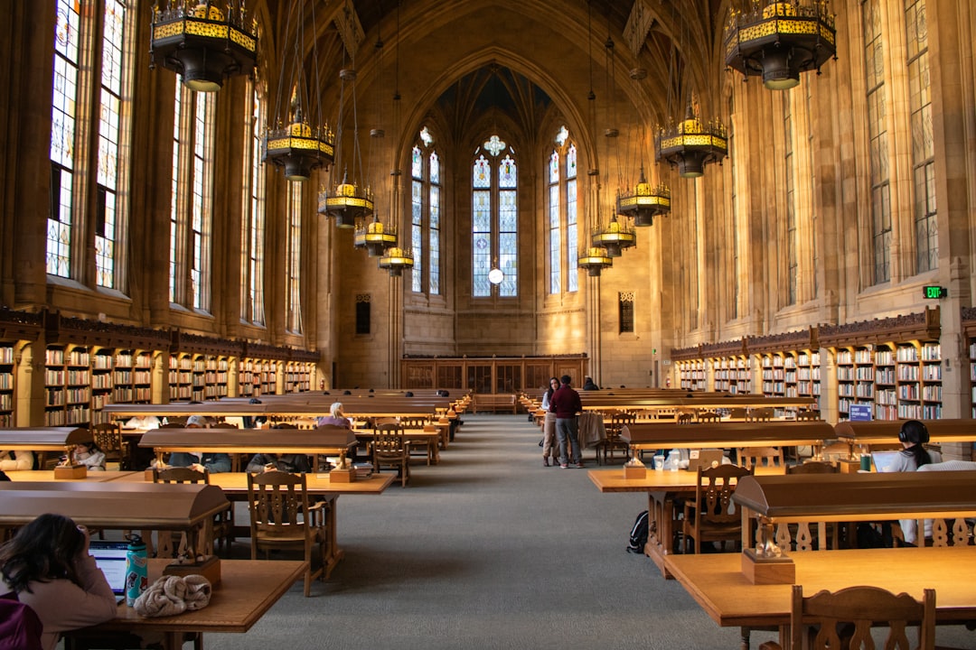 A spacious library filled with numerous tables and chairs for reading and studying.