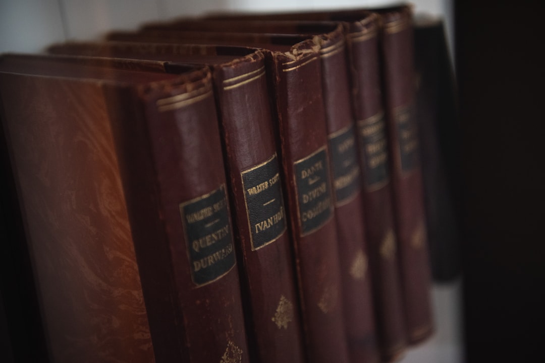 a row of red books sitting on top of a shelf