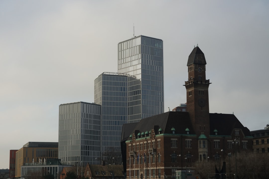 Modern skyscrapers and historic building under cloudy sky