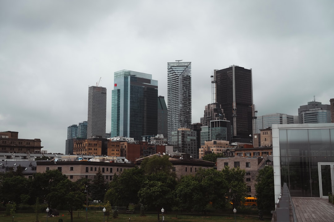 City skyline with modern and older buildings under cloudy sky