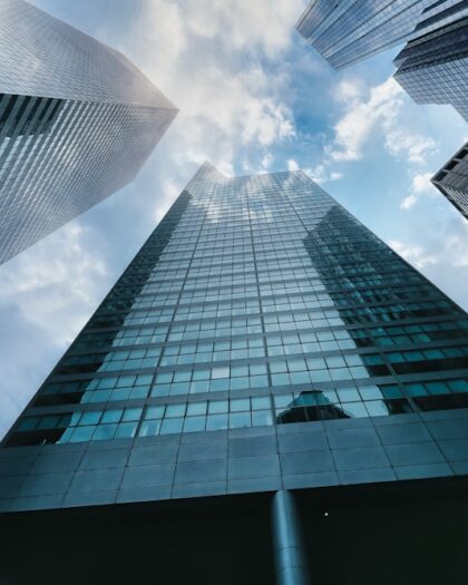 low angle photography of high rise building under white clouds during daytime