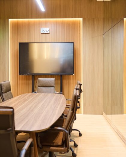 Modern conference room with oval table and chairs.