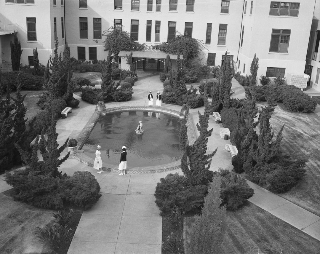 People gathered around a circular pool in a courtyard.