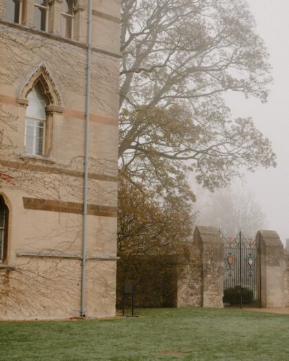Old stone building with ornate windows and a foggy gate.