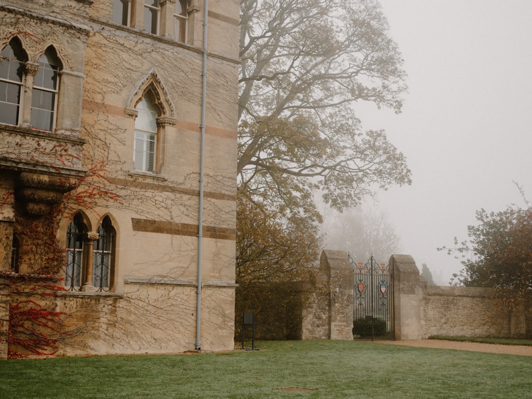 Old stone building with ornate windows and a foggy gate.